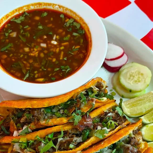 Birria tacos with a bowl of consomé