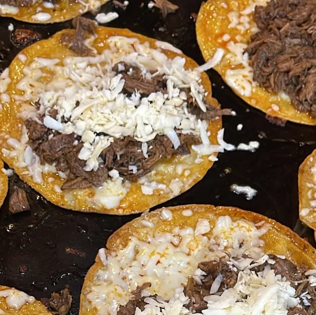 Tostadas topped with shredded meat and cheese